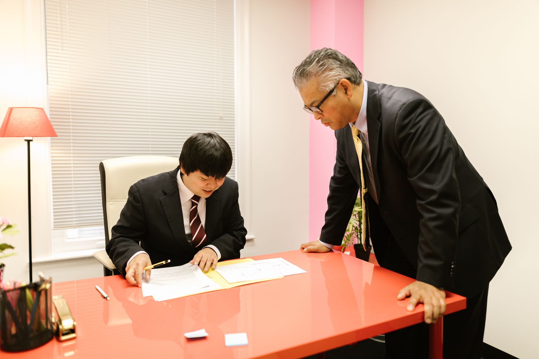 Two people looking over documents at a desk