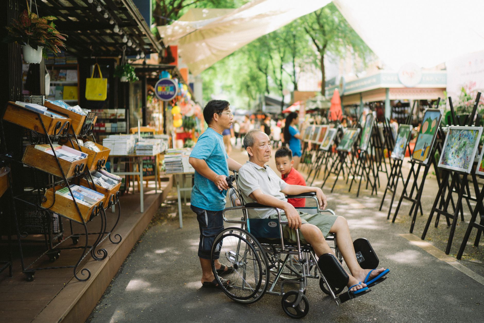 An older man in a wheelchair visiting an outdoor market